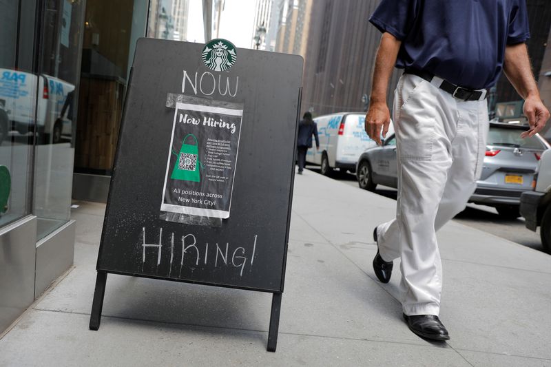 A sign advertising job openings is seen outside of a