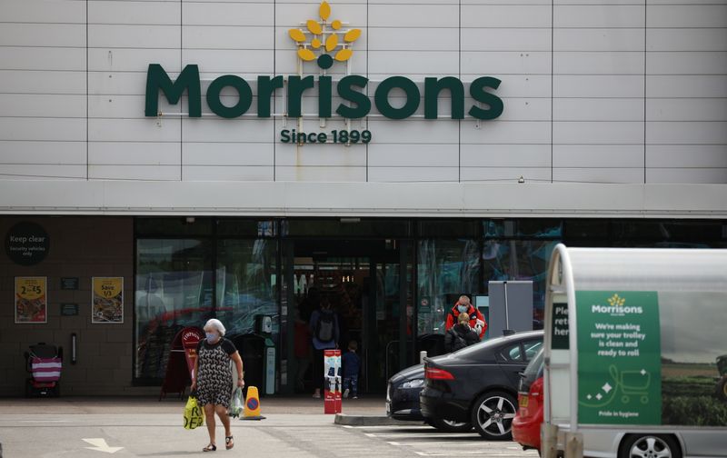 A customer carries a shopping bag outside a Morrisons supermarket