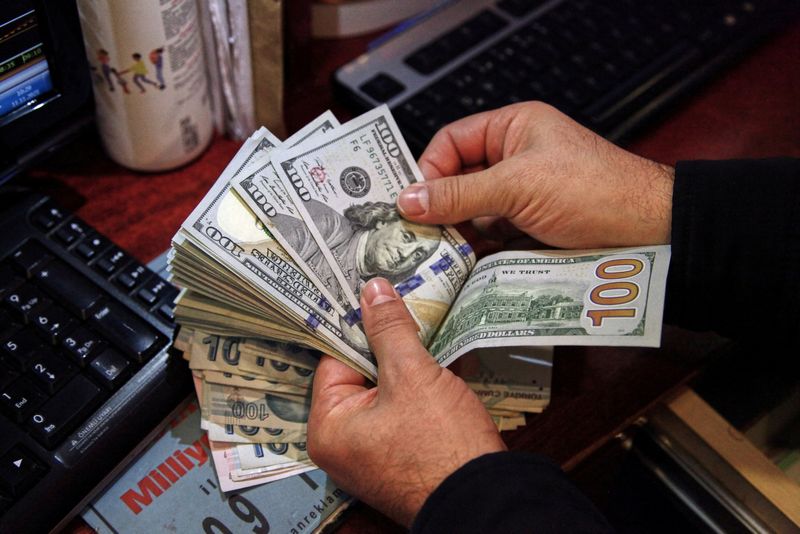 FILE PHOTO: A money changer counts U.S. dollar banknotes at