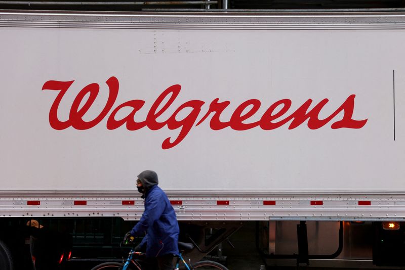FILE PHOTO: A person rides past a Walgreens truck, owned