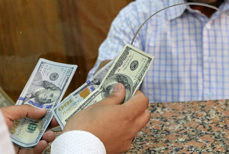 FILE PHOTO: A customer exchanges U.S. dollars to Egyptian pounds