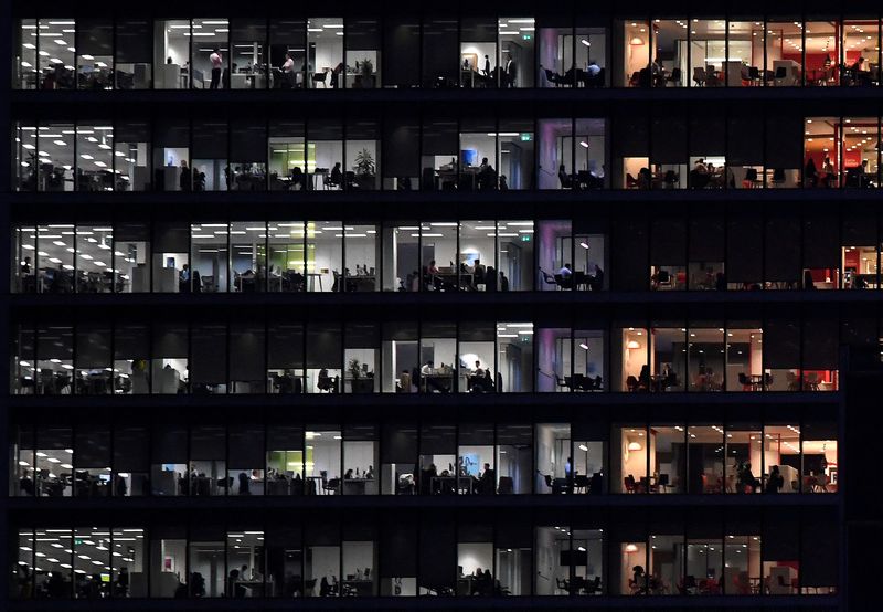 Workers are seen in an office tower in the Canary