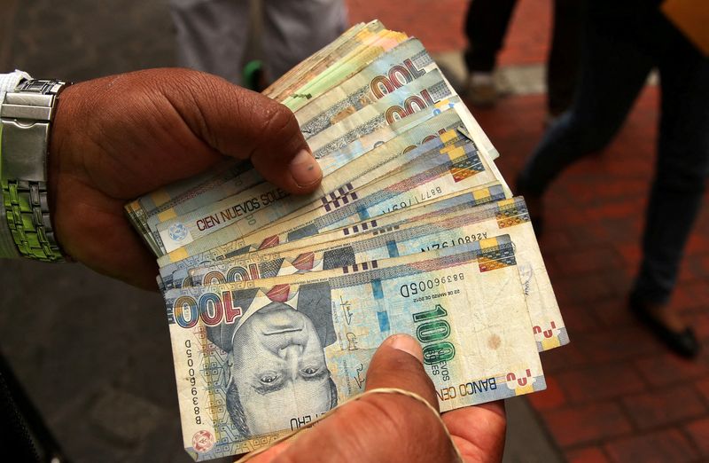 FILE PHOTO: A money changer holds Peruvian Sol bills at