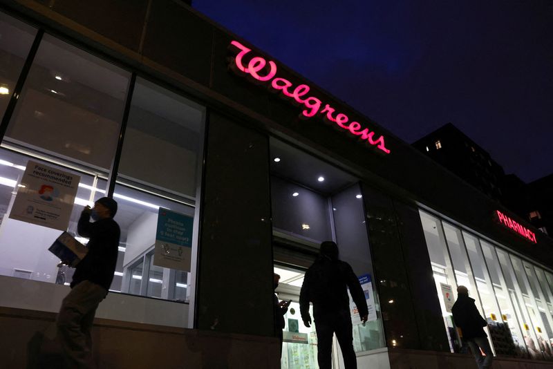 FILE PHOTO: People walk by a Walgreens, owned by the