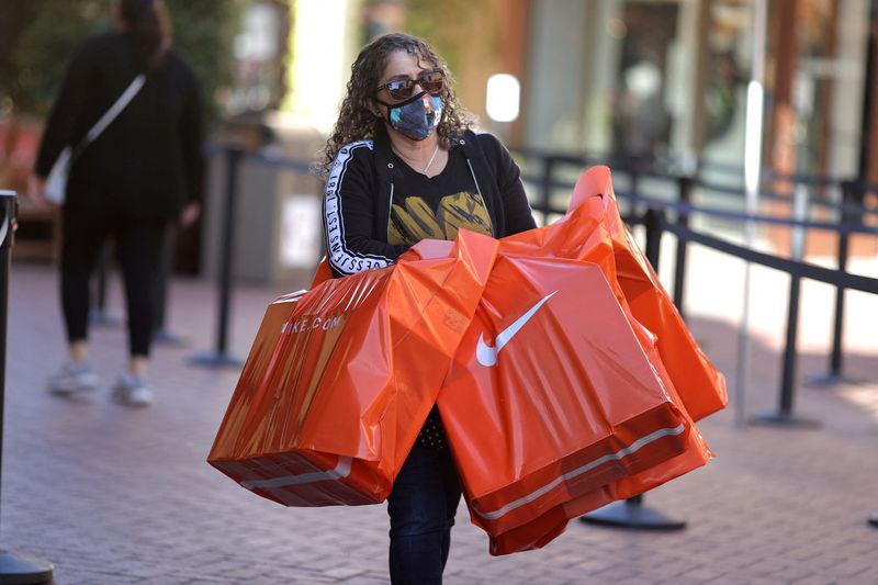 FILE PHOTO: A woman carries Nike shopping bags at the