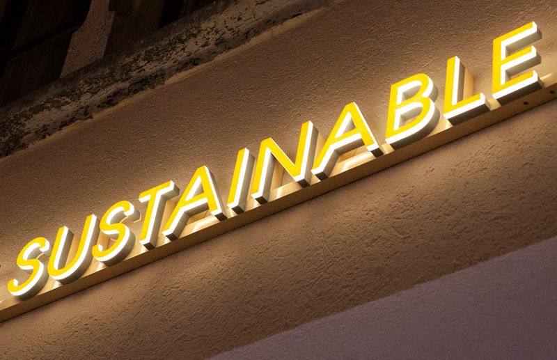 The illuminated word “sustainable” is seen outside a shop in