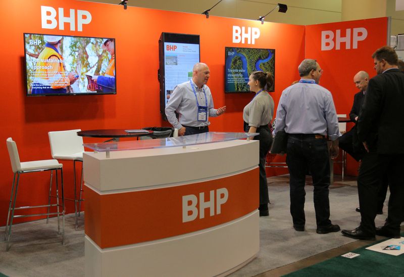 Visitors to the BHP booth speak with representatives during the
