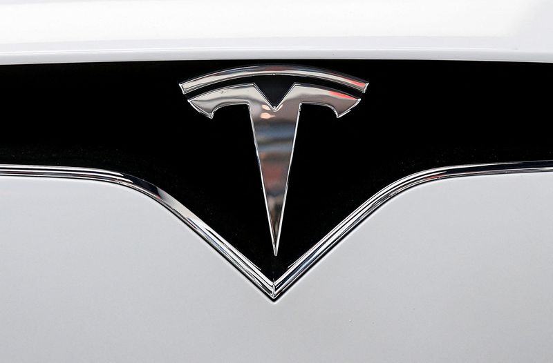 The Tesla logo is seen on a car at Tesla