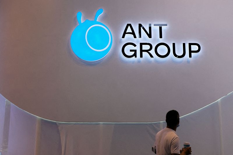 FILE PHOTO: Man walks past an Ant Group logo in