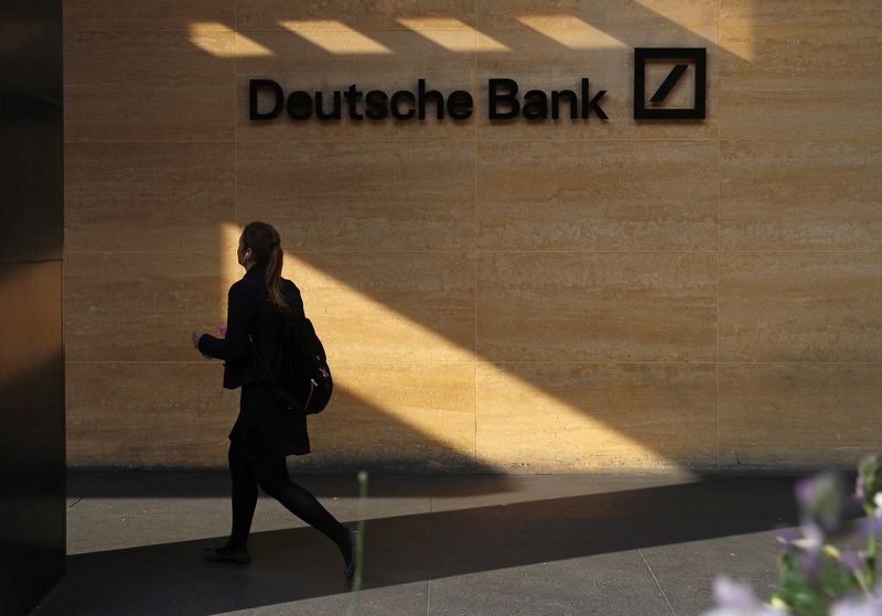 FILE PHOTO: A woman walks past a Deutsche Bank office