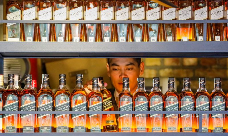 FILE PHOTO: A bartender takes a bottle of Johnnie Walker