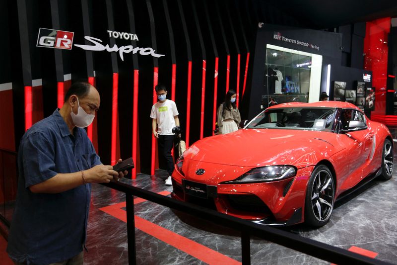 People stand near a Toyota GR Supra at the Indonesia