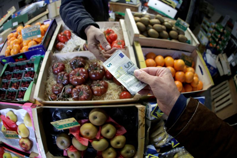 FILE PHOTO: A shopper pays with a Euro bank note