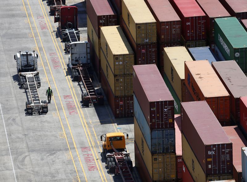 Workers stack empty shipping containers for storage at Wando Welch