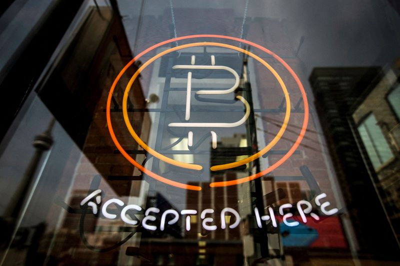 FILE PHOTO: A Bitcoin sign is seen in a window