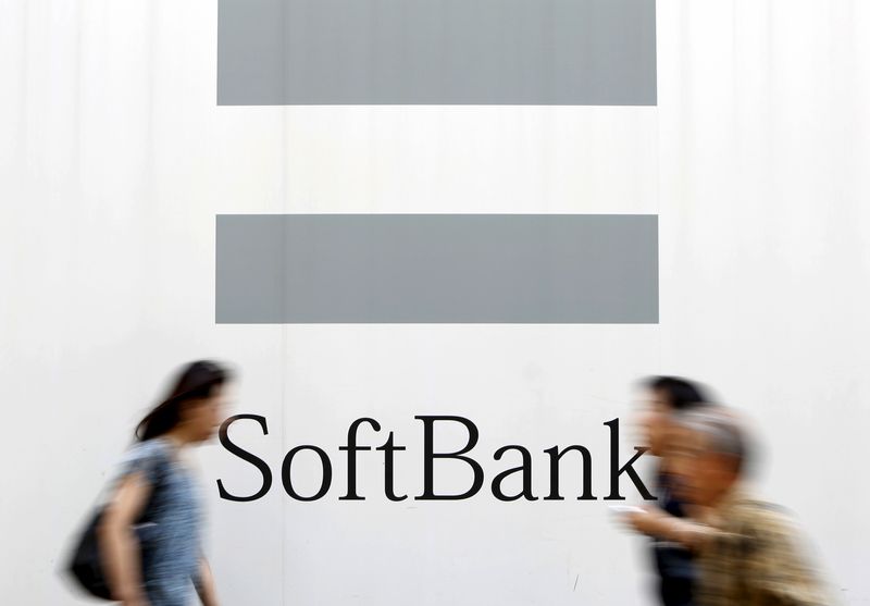 People walks past a logo of SoftBank Corp on a