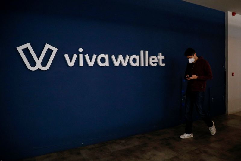 An employee walks past the Viva Wallet logo at the