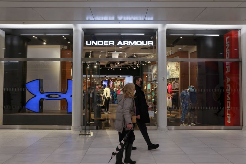 FILE PHOTO – People walk by an Under Armour store