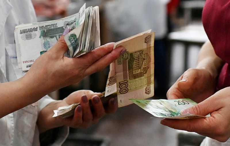 FILE PHOTO: Vendors count Russian rouble banknotes at a market