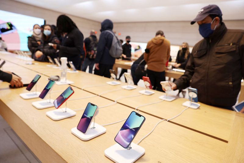 FILE PHOTO – People shop for smartphones in an Apple