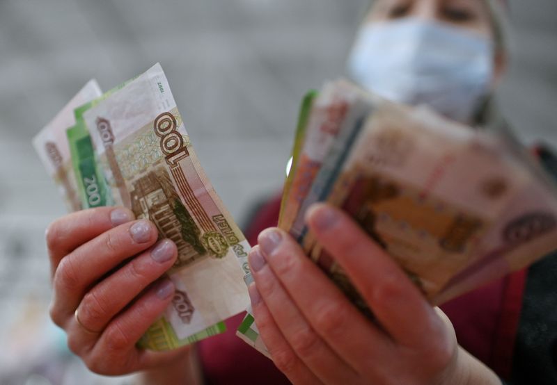 A vendor counts Russian rouble banknotes at a market in