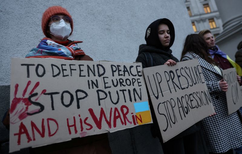 Activists hold banners in front the Ukrainian Foreign Ministry as