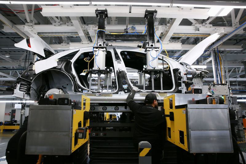 FILE PHOTO – Workers assemble electric vehicles at the Lucid