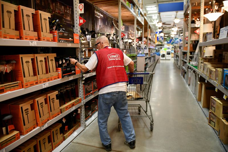 FILE PHOTO – An employee restocks items at a Lowe’s