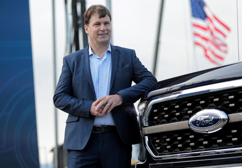 Ford Motor Co. CEO Jim Farley poses next to a