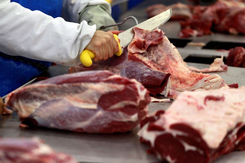 FILE PHOTO: A worker cuts up joints of beef at