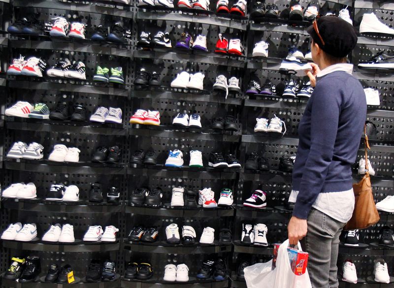 FILE PHOTO – A woman shops inside a Foot Locker