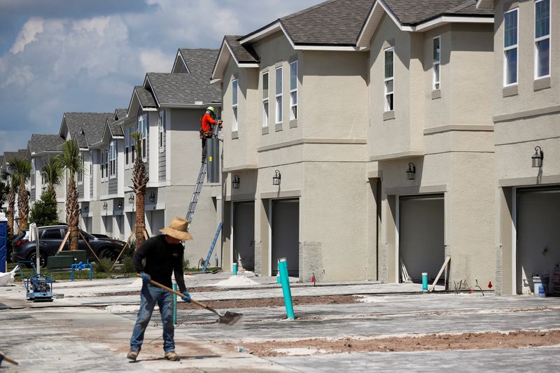 FILE PHOTO – A carpenter works on building new townhomes