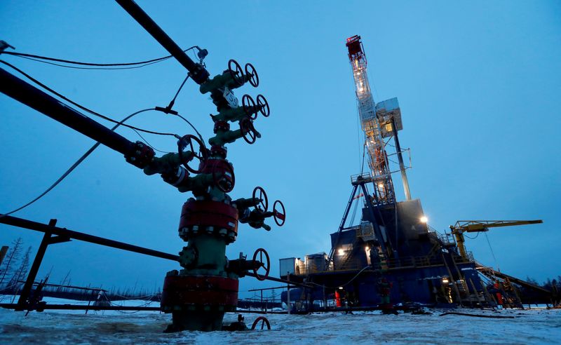 FILE PHOTO: A well head and drilling rig in the