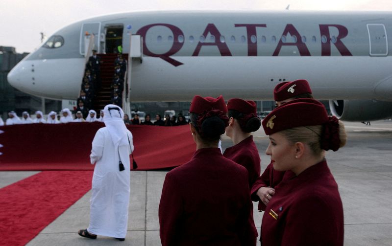 FILE PHOTO: Qatar Airways cabin crew stand in front of