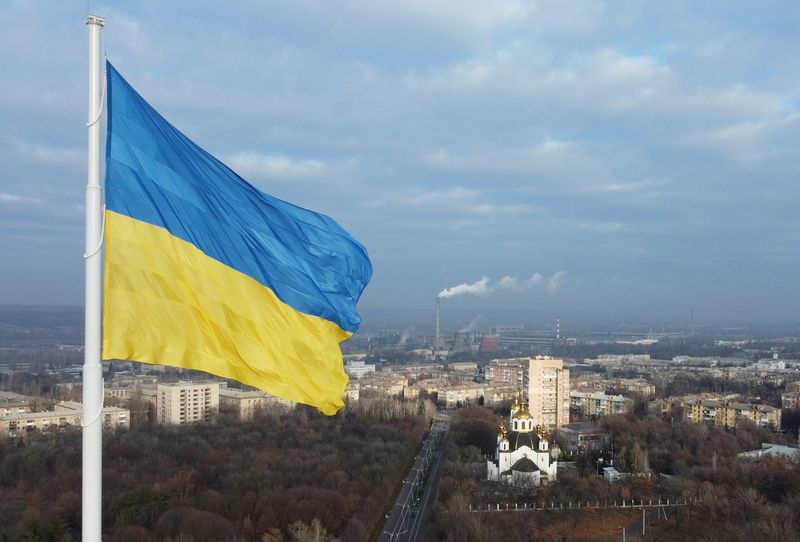 The national flag of Ukraine flies over the town of