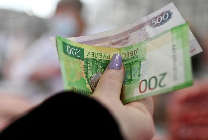 FILE PHOTO: FILE PHOTO: A customer hands over Russian rouble