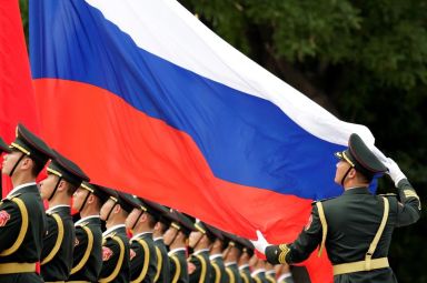 FILE PHOTO: An honour guard holds a Russia flag during