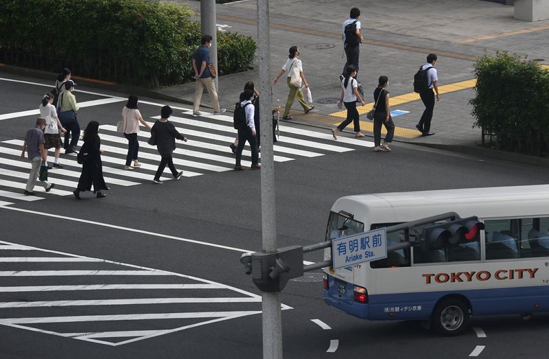 Workers cross a road during the morning rush hour in