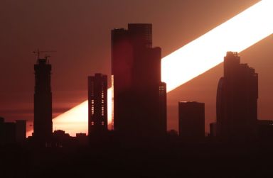 The sun rises behind the skyscrapers of the Moscow International