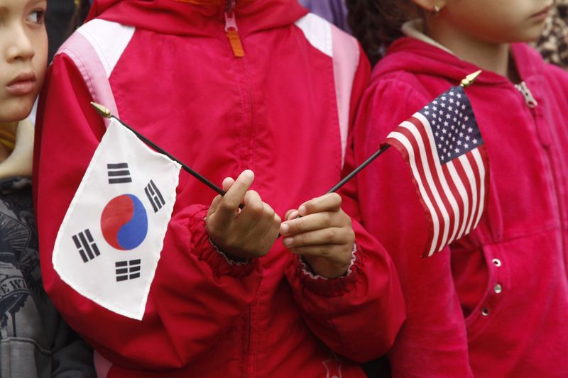 A child holds U.S. and South Korean flags prior to