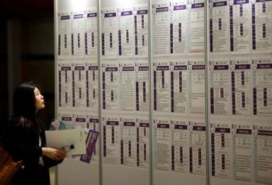A woman looks at recruiting information during a job fair
