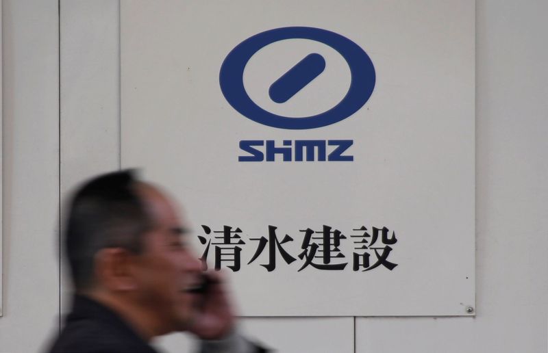 Man walks past the logo of Shimizu Corp outside a