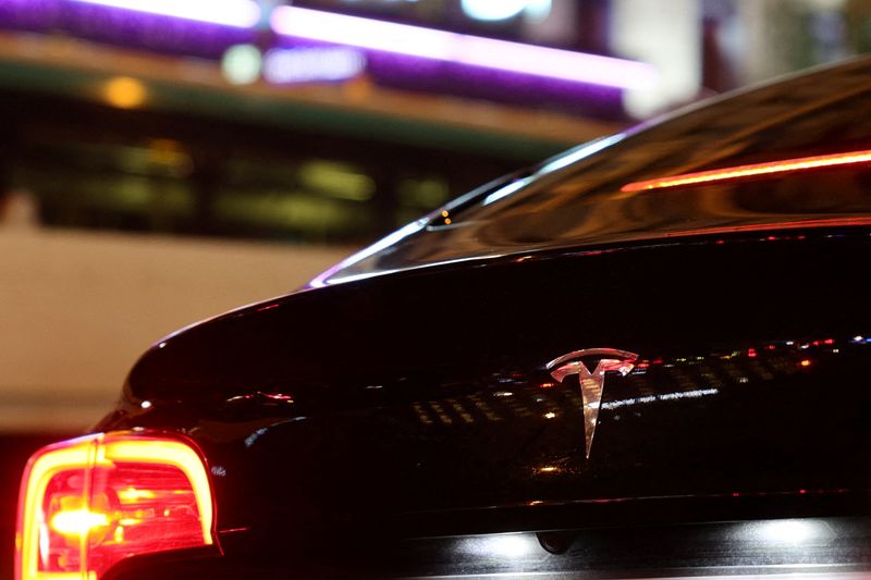 A Tesla logo is seen on a Parisian taxi car