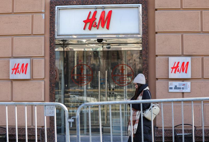 A woman walks past a closed H&M store in Moscow
