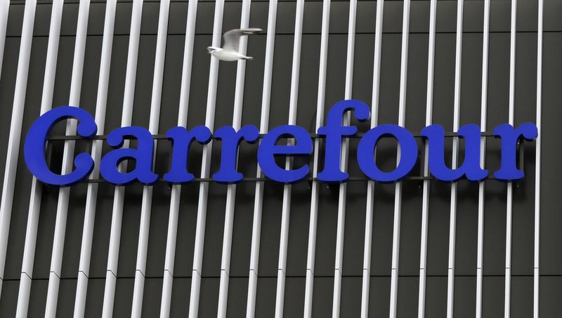 A seagul flies over the logo of Carrefour at a
