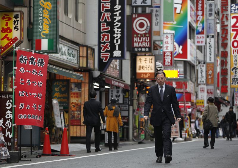 A man walks through a street in Tokyo’s Shinjuku district