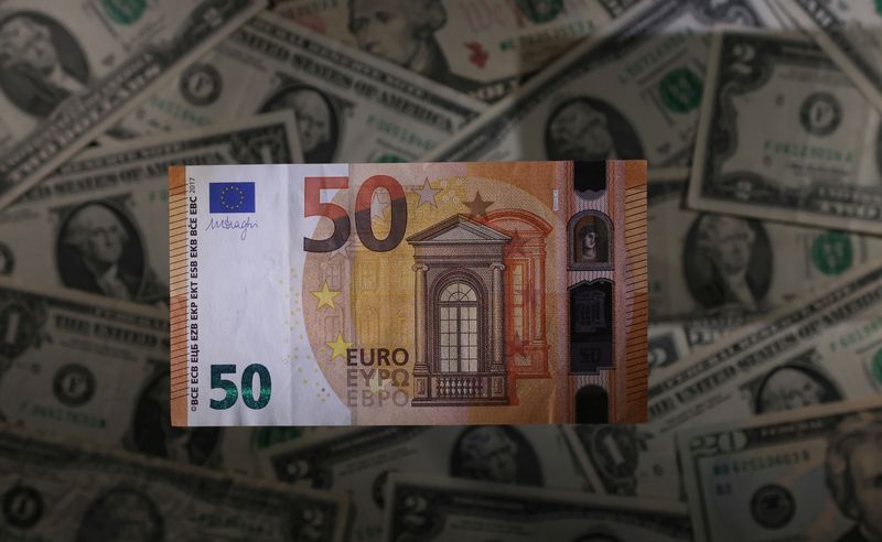 Euro banknote is seen placed on U.S. Dollar banknotes in