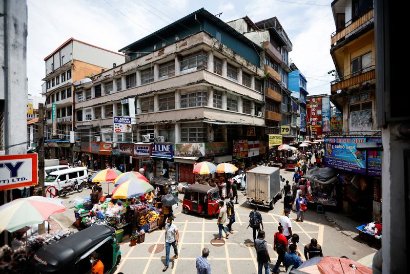 People walk along the Pettah Market, amid the country’s economic