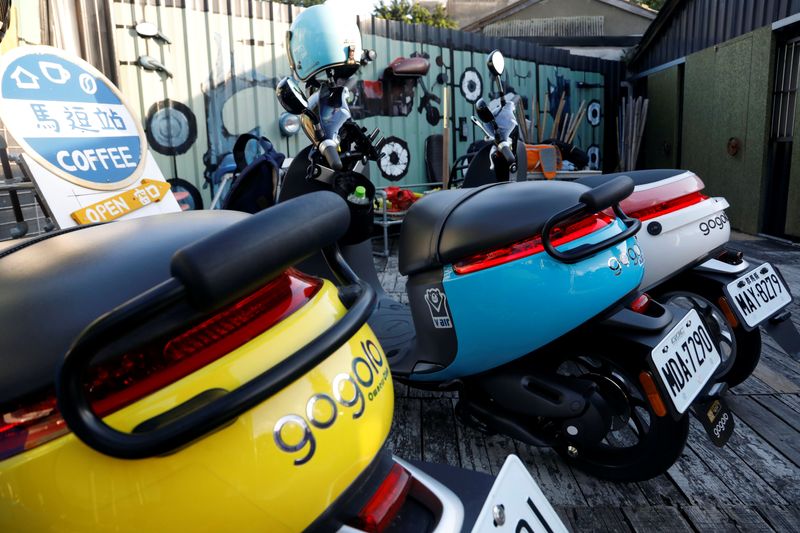 Gogoro’s electric scooters are seen parked near a charging station