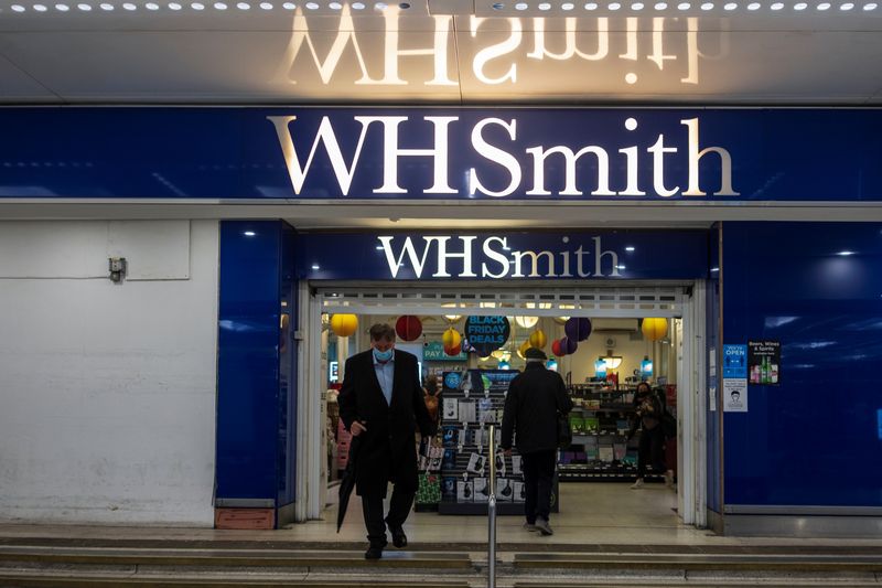 A person wearing a mask leaves a WH Smith store